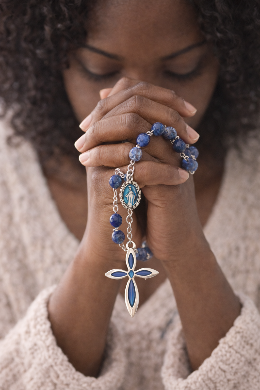 Hands in prayer with lapis lazuli rosary